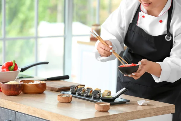 Beautiful Asian chef cooking in kitchen