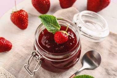 Masada bir kavanoz lezzetli çilek reçeli, yakın plan.