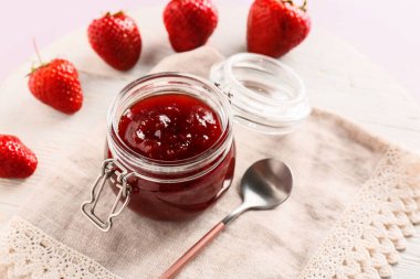 Masada bir kavanoz lezzetli çilek reçeli, yakın plan.