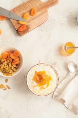 Kaynamış pirinç ve beyaz arka planda meyveli kase.