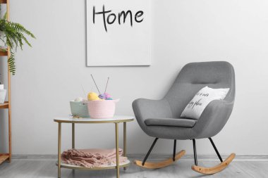 Masada örgü ipliği ve odada koltuk olan hasır sepetler.