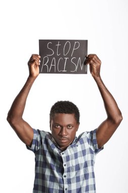 Beyaz arka planda afişi olan üzgün bir Afro-Amerikalı. Irkçılığı bırak