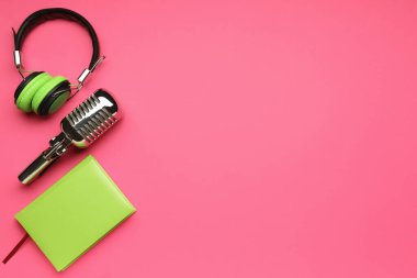 Renkli arka planda mikrofon ve defter olan kulaklıklar