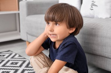 Evde kulak ağrısı çeken küçük bir çocuk.