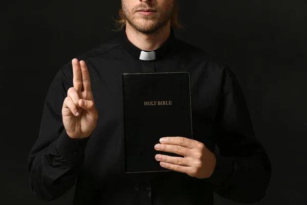 Schöner Priester Mit Bibel Auf Dunklem Hintergrund — Stockfoto