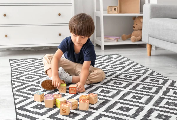 Little boy with autistic disorder playing with cubes at home