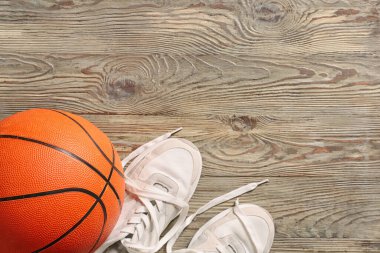 Tahta arka planda ayakkabılarla basketbol oynamak için top