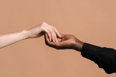 Beyaz kadın ve Afro-Amerikalı erkek renk geçmişinde el ele tutuşuyorlar. Irkçılık kavramı