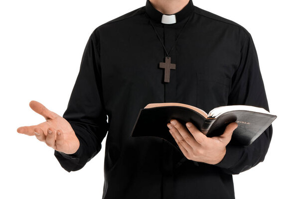 Handsome priest with Bible on white background