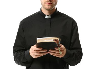 Handsome priest with Bible on white background clipart