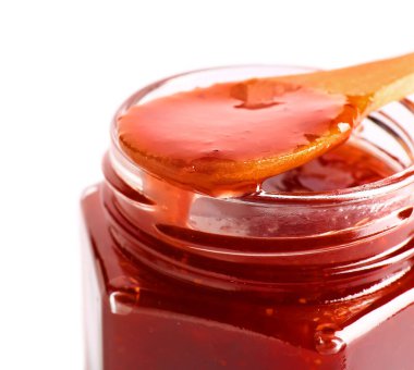Beyaz arka planda lezzetli çilek reçeli kavanozu, yakın plan.
