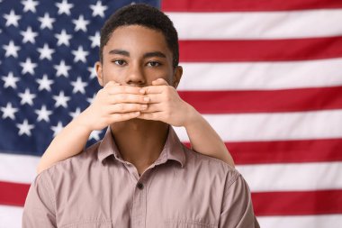 Ulusal bayrağın yanında üzgün Afro-Amerikalı bir gencin ağzını kapatan kişi. Irkçılığı bırak