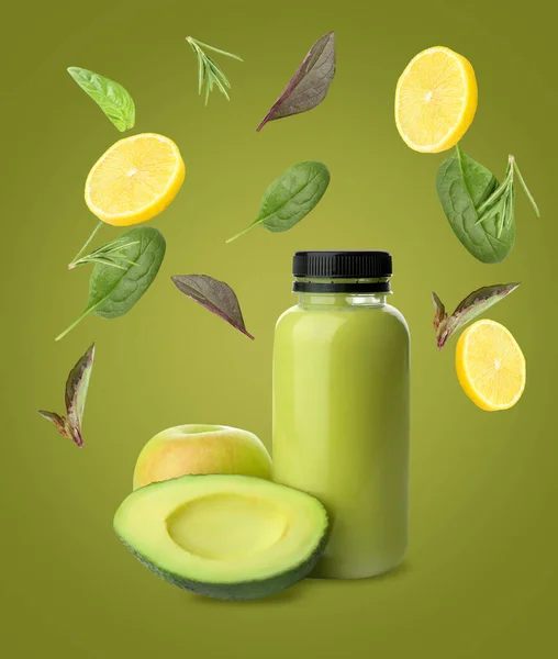 Bottle of fresh juice and flying ingredients on color background