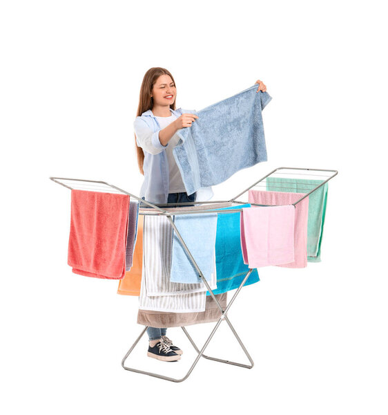 Woman with clean towels and clothes dryer on white background