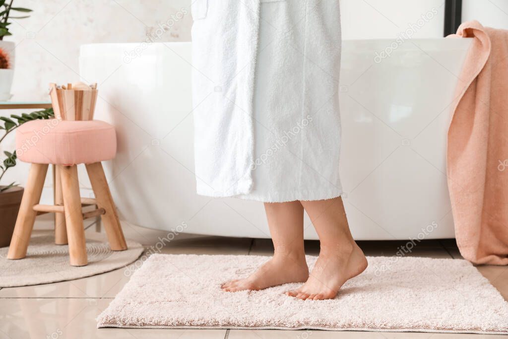 Woman standing on soft rug after bathing