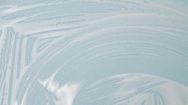 Ev hanımı renk arka planında pencereyi temizler