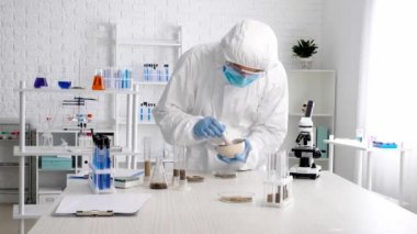 Bilimadamı laboratuvarda toprak örneklerini inceliyor