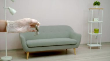 Koruyucu eldivenli insanlar odanın anahtarlarını birbirlerine veriyorlar.