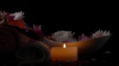 Pamuk havlular ve koyu arkaplanda çiçekler ile güzel bir spa kompozisyonu