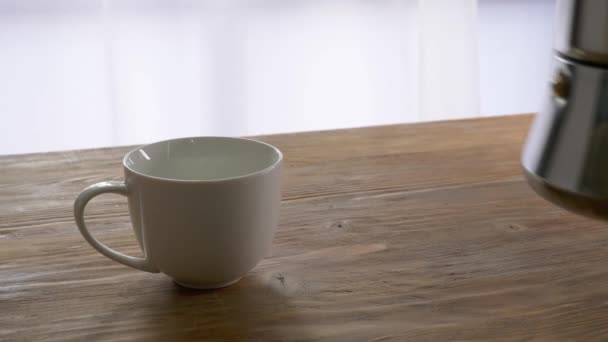 Ρίχνει Ζεστό Καφέ Από Την Κατσαρόλα Στο Κύπελλο Στο Τραπέζι — Αρχείο Βίντεο