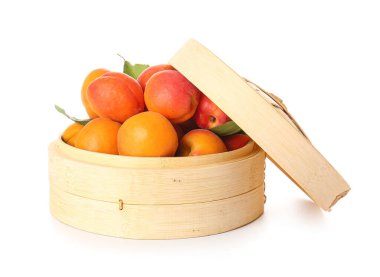 Beyaz arka planda lezzetli olgun kayısılarla dolu bir kutu