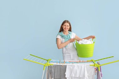 Kurutucuya temiz giysiler asan bir kadın.