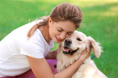 Parkta sevimli köpeği olan genç bir kadın.
