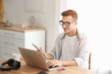 Bilgisayarlı bir adam evde online bilet ayırtıyor.