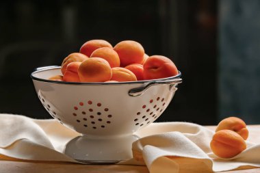 Masada lezzetli olgun kayısıları olan kolander.