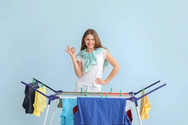 Vrouw Opknoping Schone Kleren Droger Tegen Kleur Achtergrond — Stockfoto