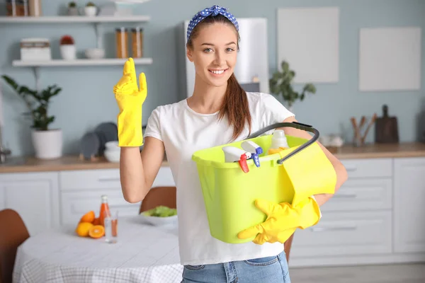 台所で掃除用品を持つ若い女性 — ストック写真