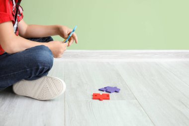 Evde yapboz yaparken otistik bozukluğu olan küçük bir çocuk.