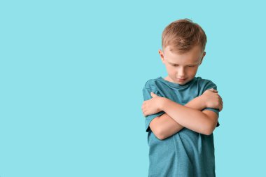 Sad little boy with autistic disorder on color background clipart