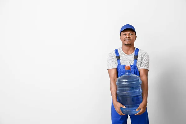 Uomo Consegna Afro Americano Con Bottiglia Acqua Sfondo Chiaro — Foto Stock