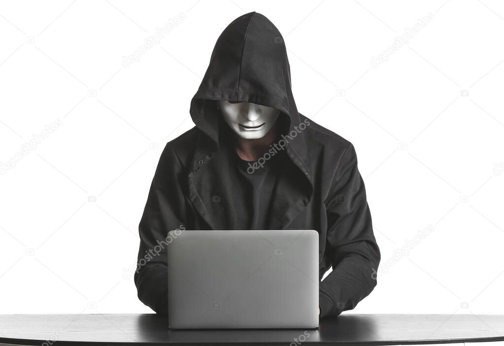 Professional hacker using laptop at table against white background