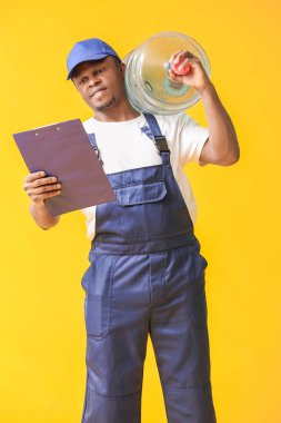 Siyah arka planda bir şişe suyu olan Afro-Amerikalı teslimatçı.