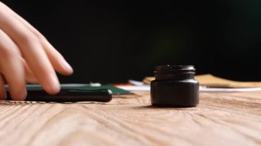 Dolma kalemi masaya mürekkep şişesinin yanına koyan adam.