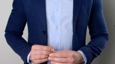 Gri arka planda evden anahtarı gösteren adam, yakın plan