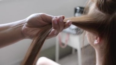 Güzellik salonunda müşteriyle çalışan kuaför, yakın plan.