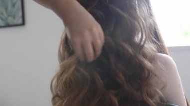 Güzellik salonunda müşteriyle çalışan kuaför, yakın plan.