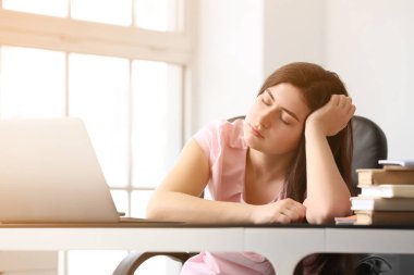 Yorgun öğrenci masada uyuyor.