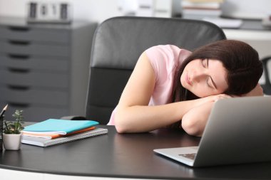 Yorgun öğrenci masada uyuyor.