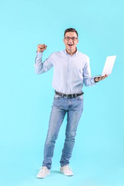 Renkli dizüstü bilgisayarı olan mutlu erkek programcı