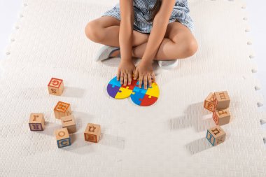 Otistik bozukluğu olan küçük bir kız yapboz yapıyor.