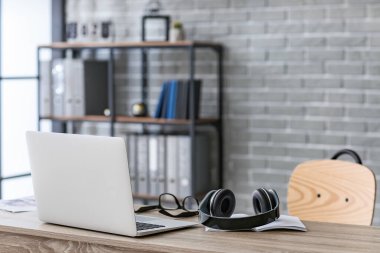 Ofisinde bilgisayar olan modern kulaklıklar.