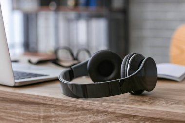 Ofisinde bilgisayar olan modern kulaklıklar.