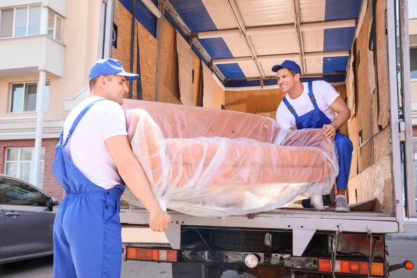 Loaders taking furniture from truck