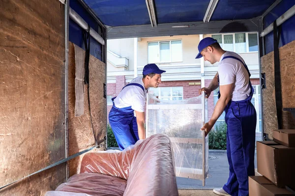 Loaders taking furniture from truck