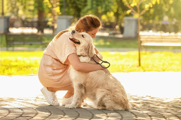 公園を歩くかわいい犬を持つ若い女性 — ストック写真