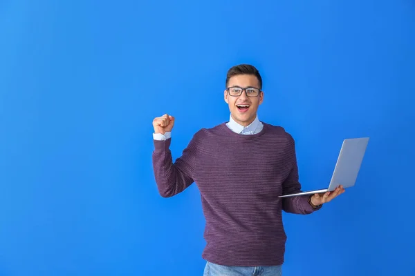 色の背景にラップトップと幸せな男性プログラマー — ストック写真